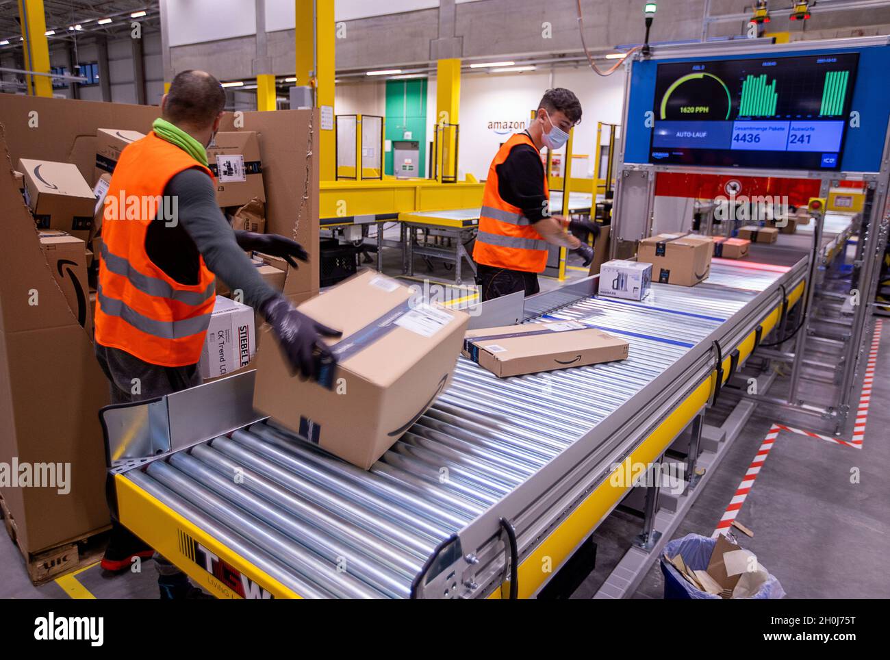 Neubrandenburg, Germany. 13th Oct, 2021. Employees sort parcels on a  conveyor belt at the new distribution center of online retailer Amazon. The  retailer's second distribution centre in Mecklenburg-Vorpommern will  officially open on