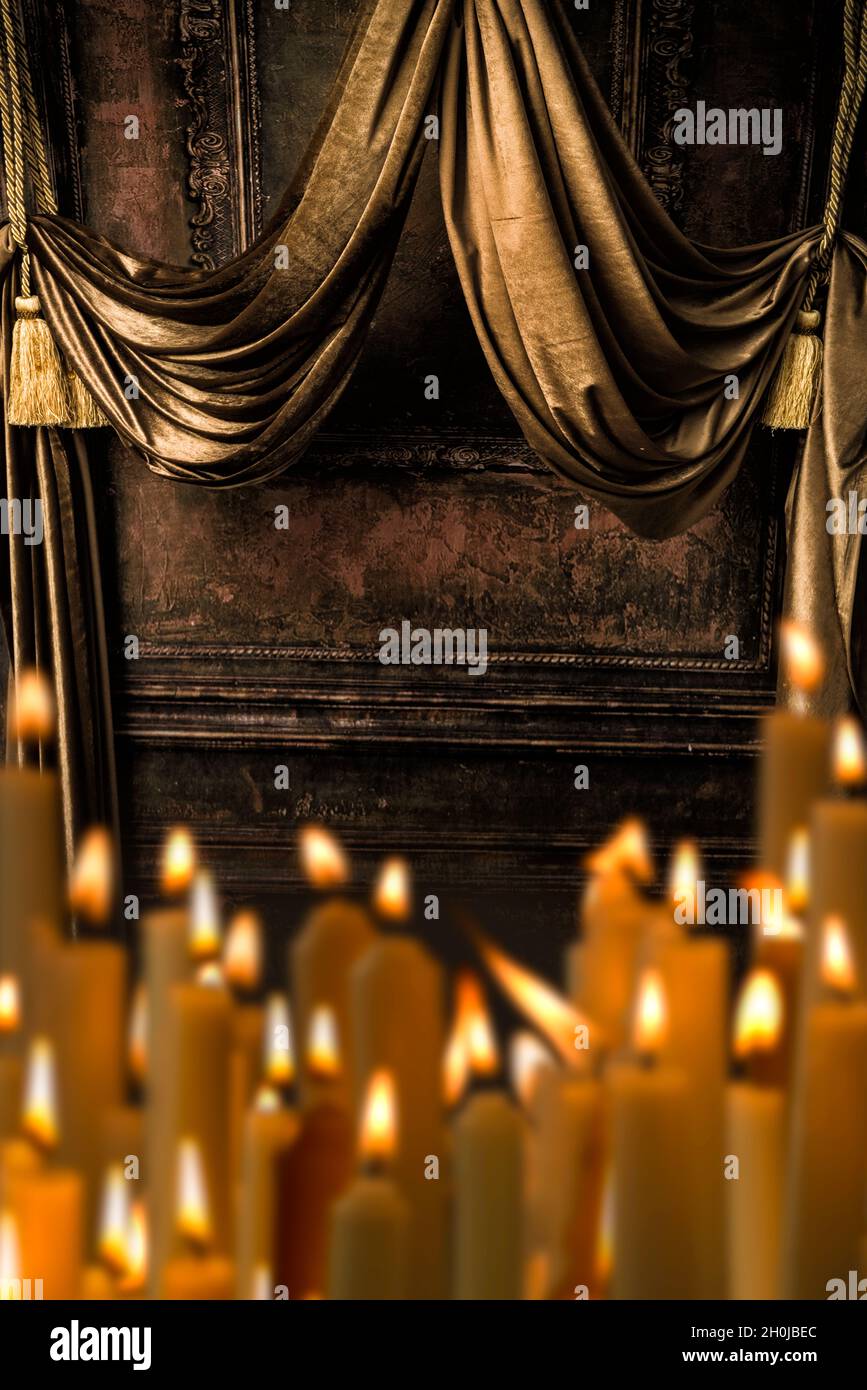 Canopy made of golden curtains with a row of burning candles in front