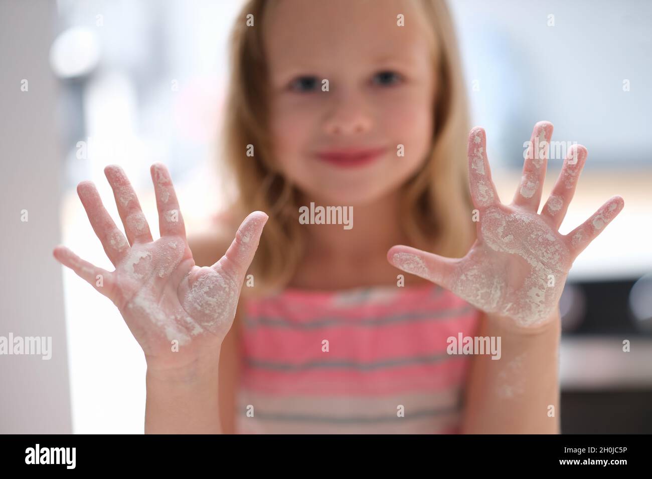 Little girl shows hands in flour. Cooking class for children Stock Photo