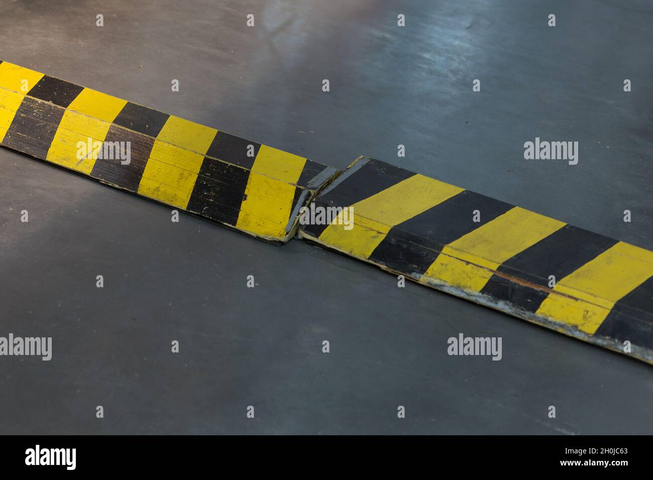 Cómo Se Dice Policía En Inglés Closeup shot of yellow and black striped plastic speed bumps on a metallic  ground Stock Photo - Alamy