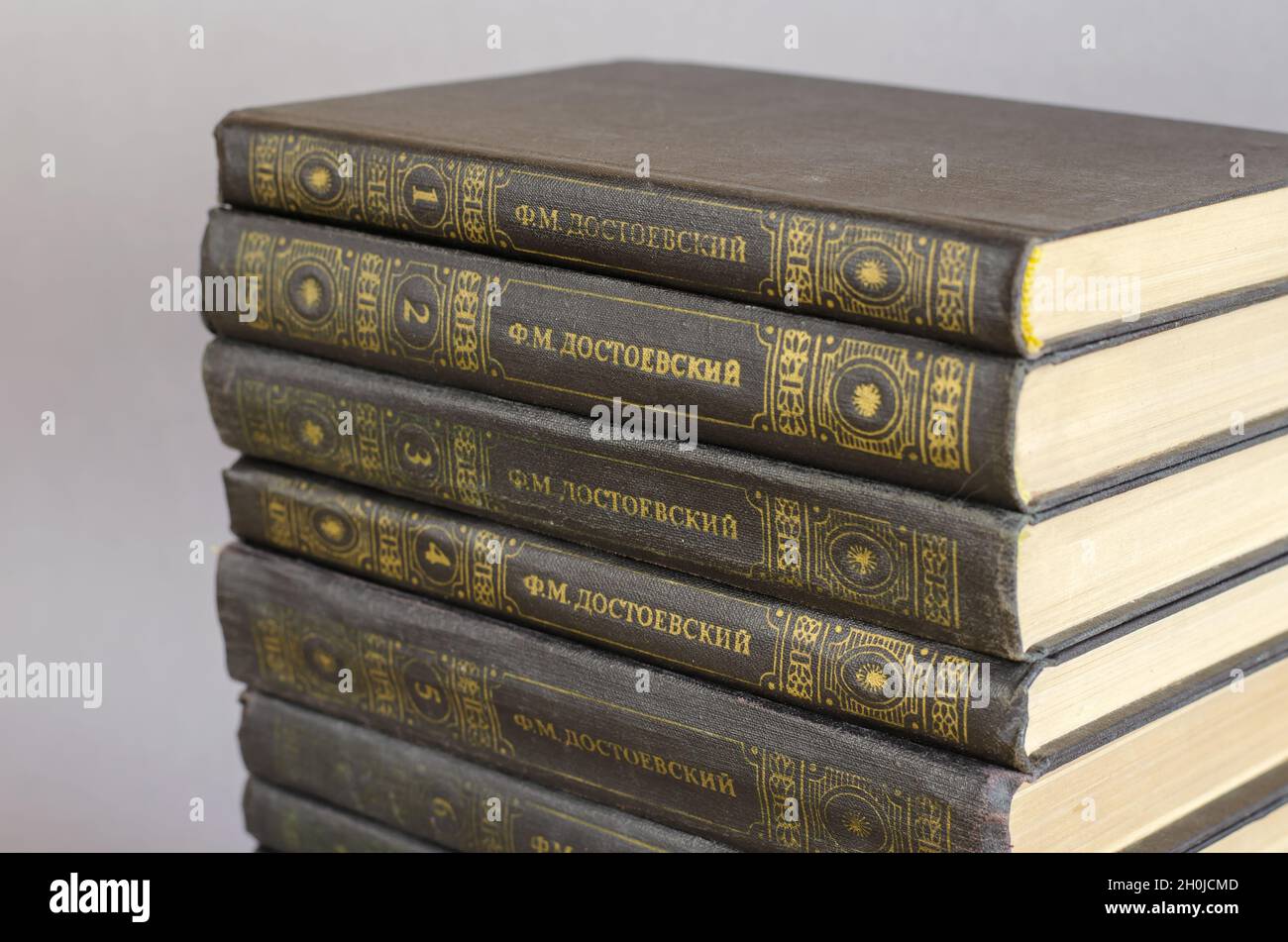 Eleven volumes by the famous Russian writer, thinker, philosopher and essayist Fyodor Dostoevsky. A stack of old hardcover books on a gray background. Stock Photo