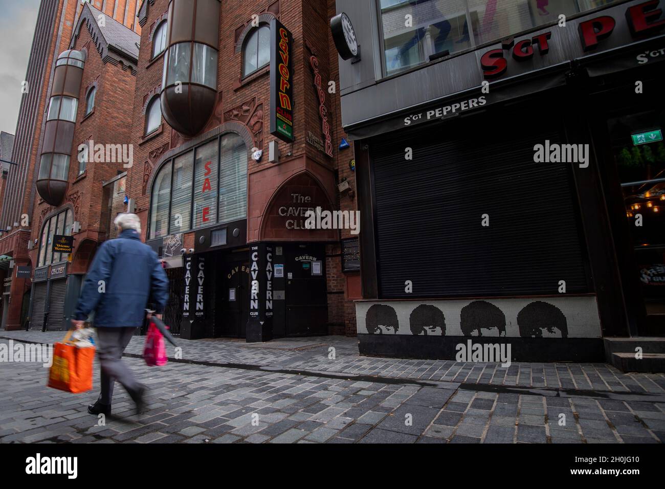 A man walks past the closed Cavern Club on Mathew Street in Liverpool as the region heads into a level 3 local lockdown, in Liverpool, U.K Stock Photo