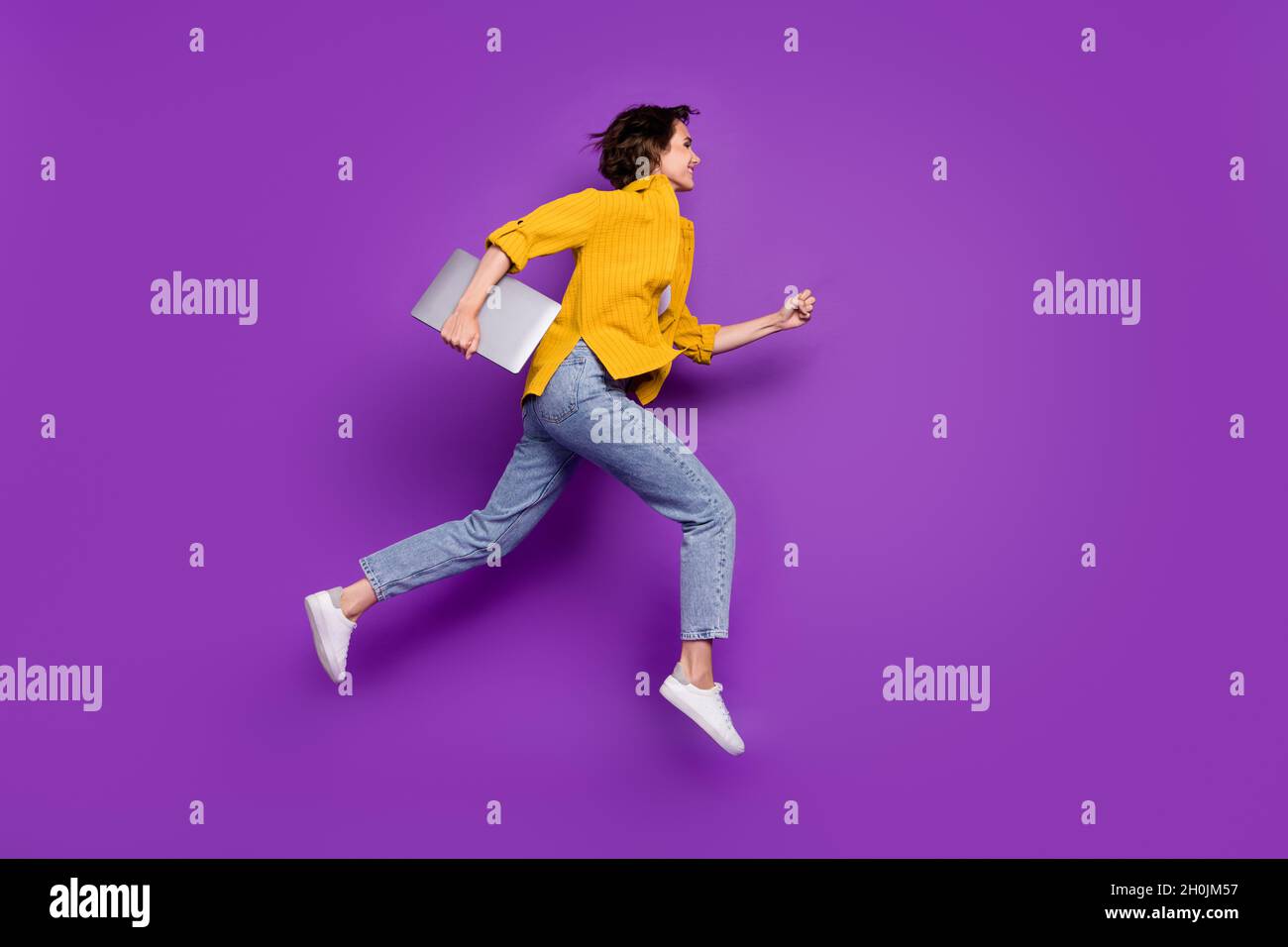 Full length body size profile side view of nice cheerful girl jumping running isolated over bright violet purple color background Stock Photo
