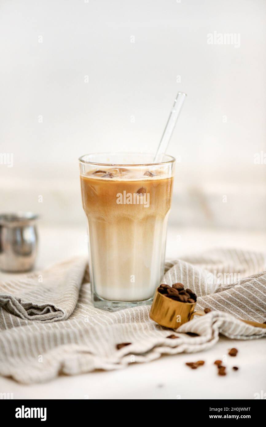 Iced latte coffee drink in tall glass over white background Stock Photo