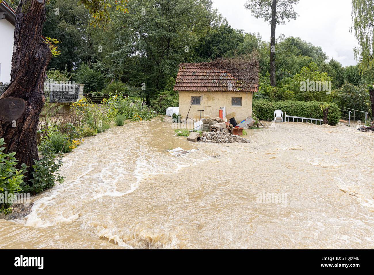 small meadow stream floods a small village after heavy rainfall, Germany, Bavaria, Isental, Dorfen Stock Photo