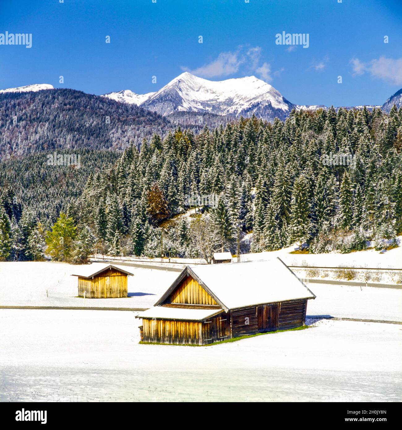 Snowy shieling with haystacks near Klais with Krottenkopf (mountain) of the Ester mountains in the background, Germany, Bavaria, Oberbayern, Upper Stock Photo