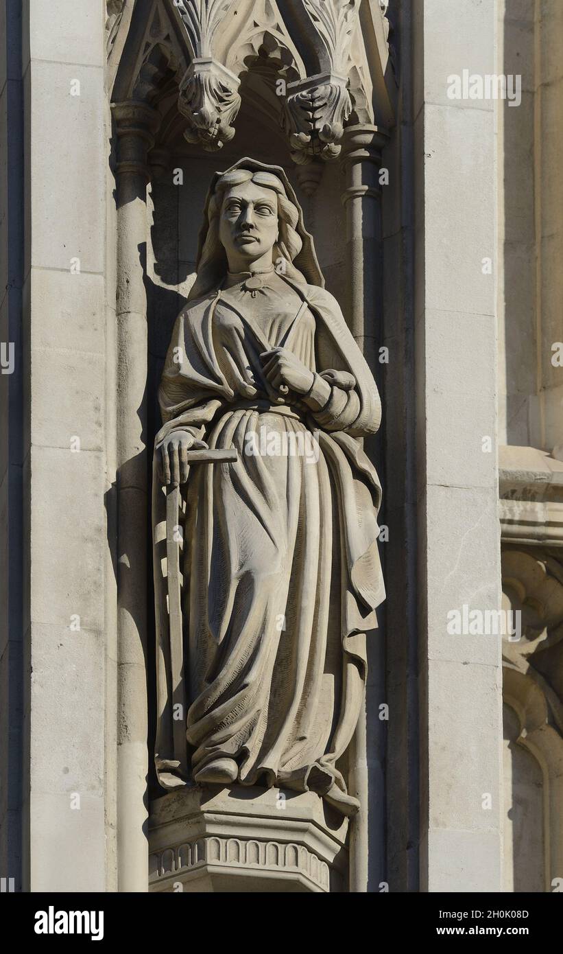 London, England, UK. Westminster Abbey - statue above main entrance. St Faith, holding the symbol of her martyrdom a gridiron Stock Photo