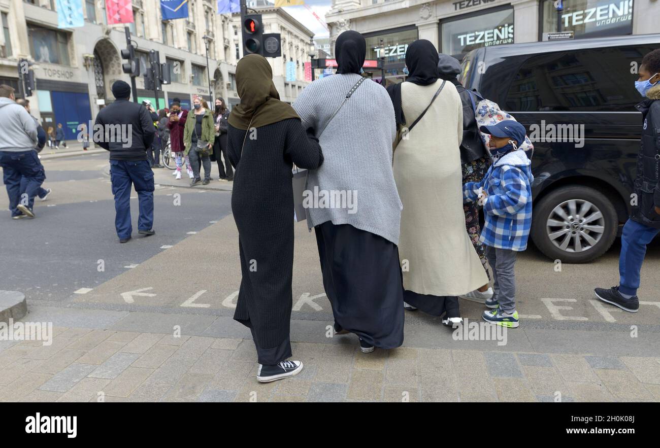 London, England, UK. Three Muslim women with covered heads crossing the road, Oxford Street Stock Photo