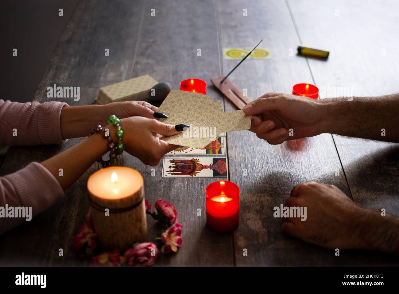 Fortune teller reading a future by tarot cards on rustic table Stock Photo