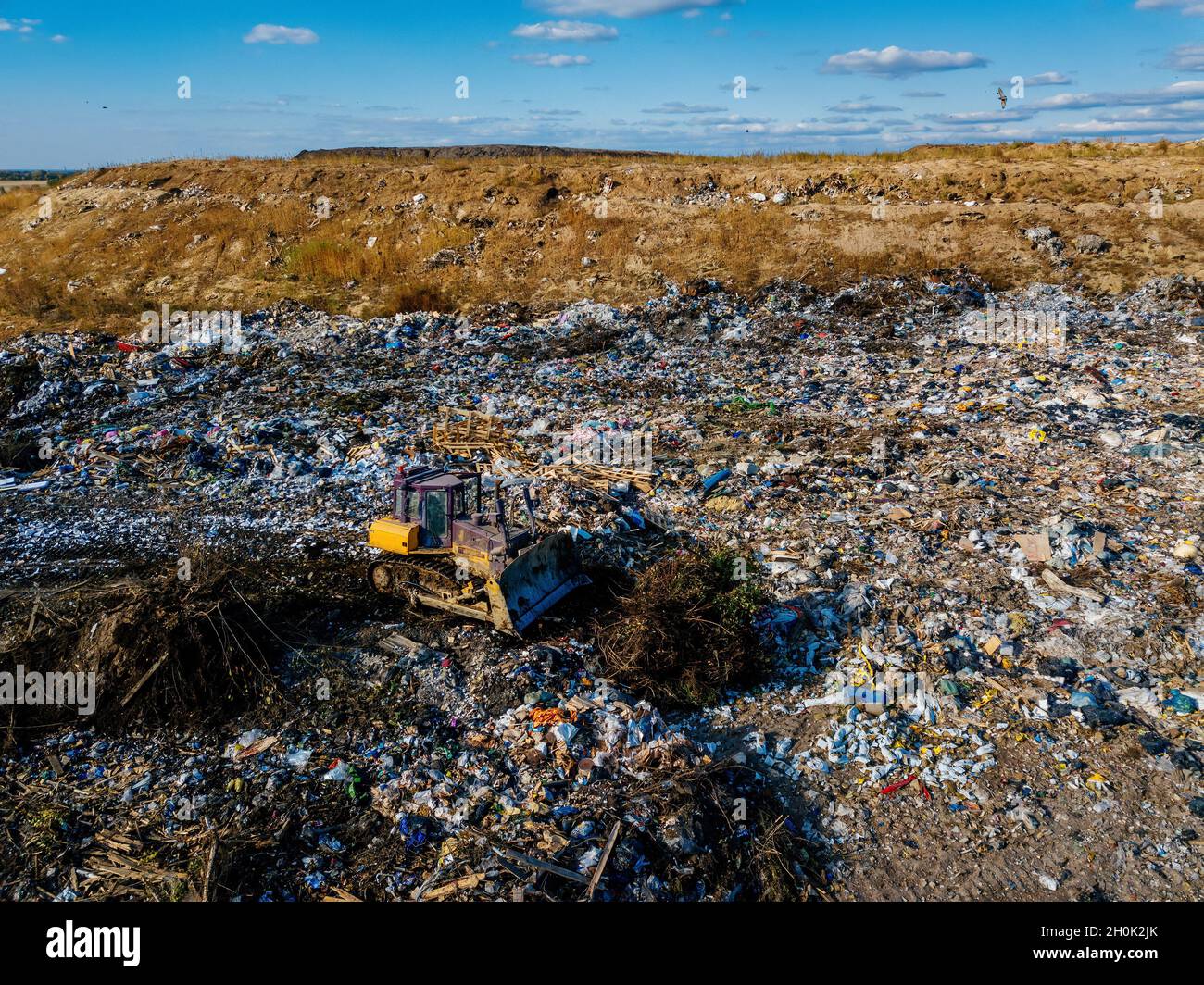 Garbage dump and working bulldozer, aerial view. Stock Photo