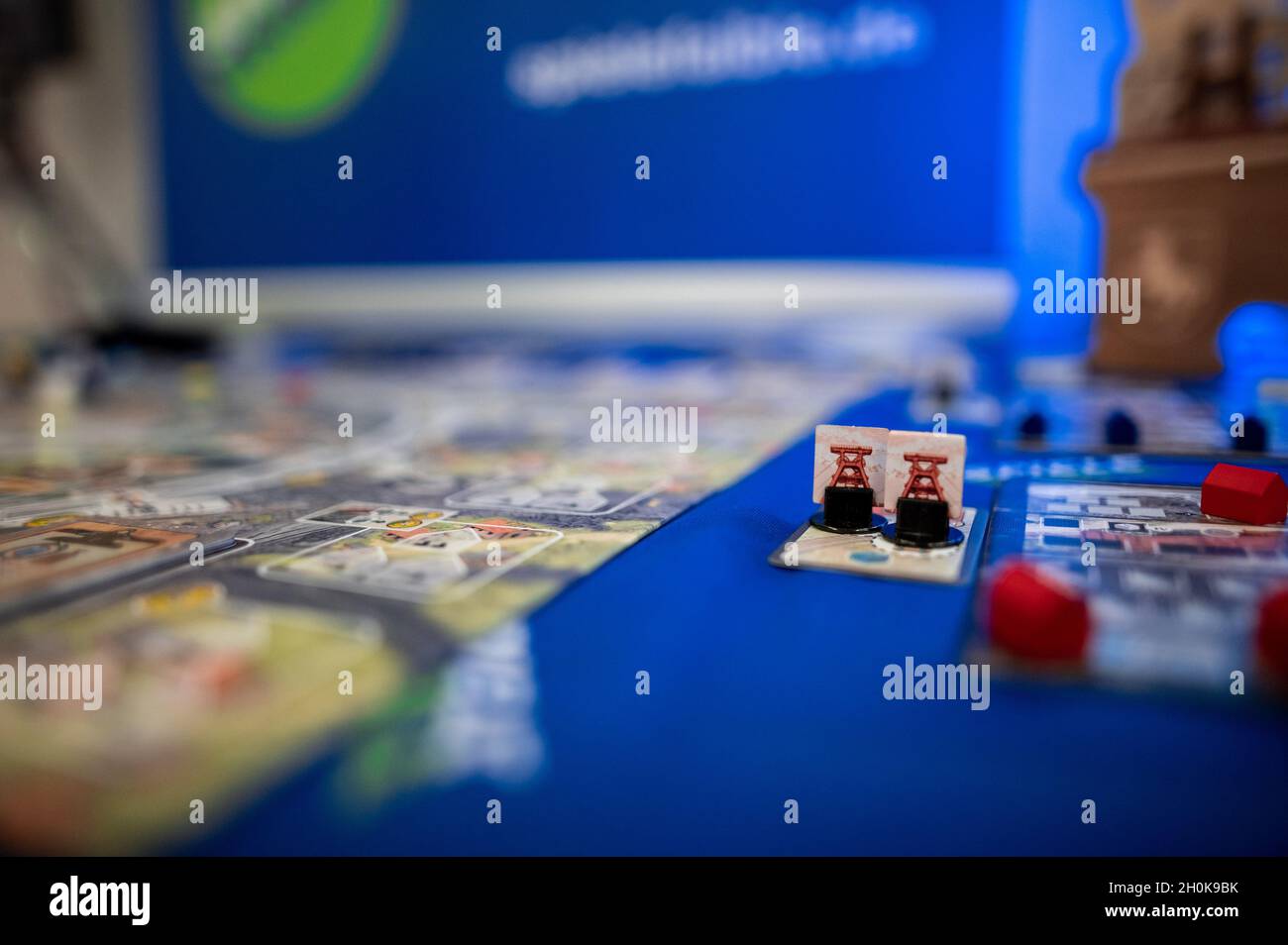 Essen, Germany. 13th Oct, 2021. Figures with a riser of the game  "Schichtwechsel" stand on a game board. Tour of the new products show  before the international games fair "Spiel'21" at Messe