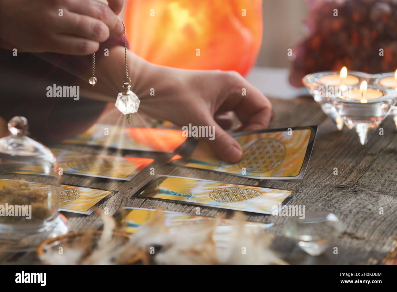 Fortune teller holding a pendulum over tarot cards Stock Photo