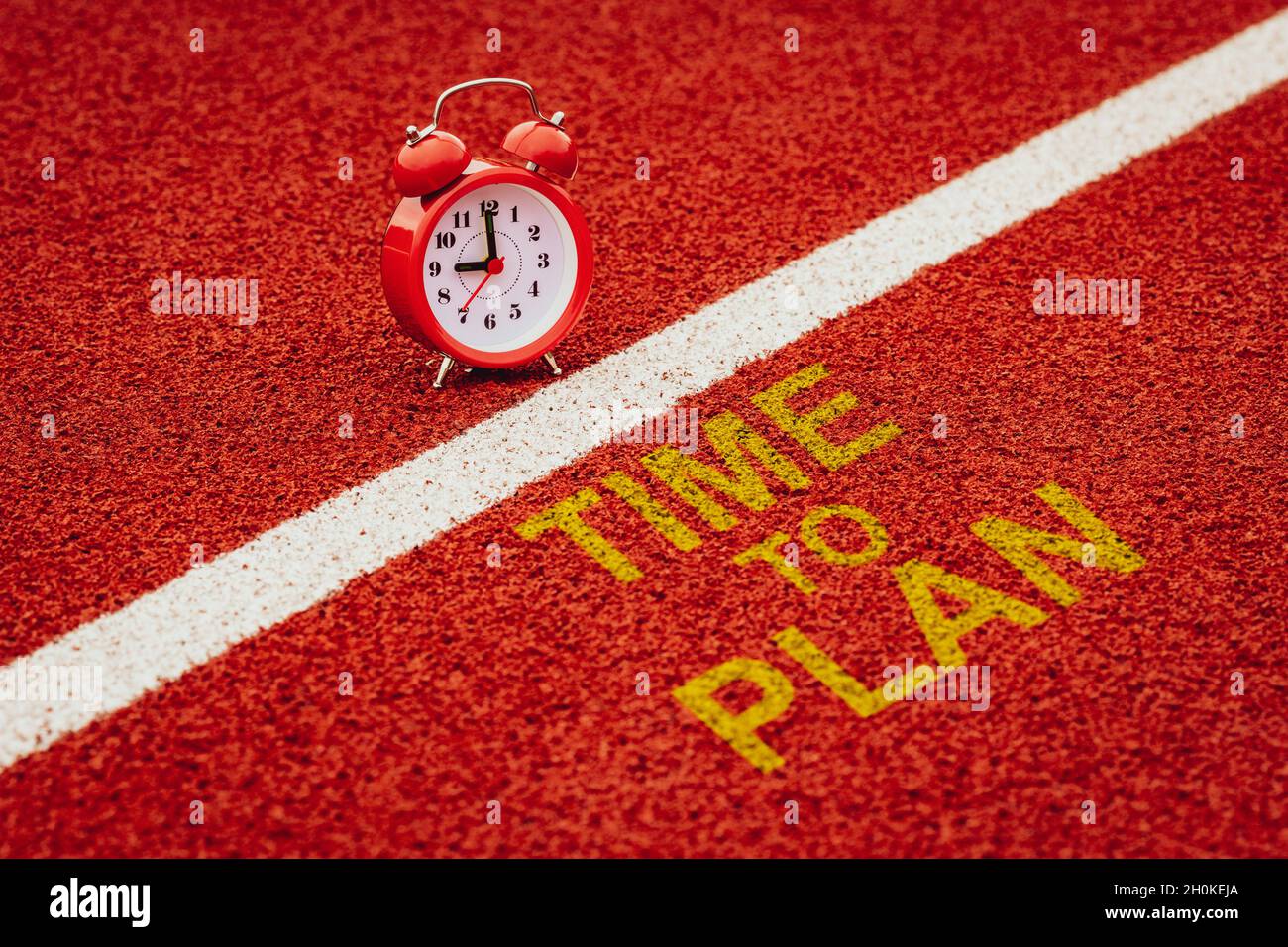 Alarm clock and 'Time to plan' is written on a run track Stock Photo