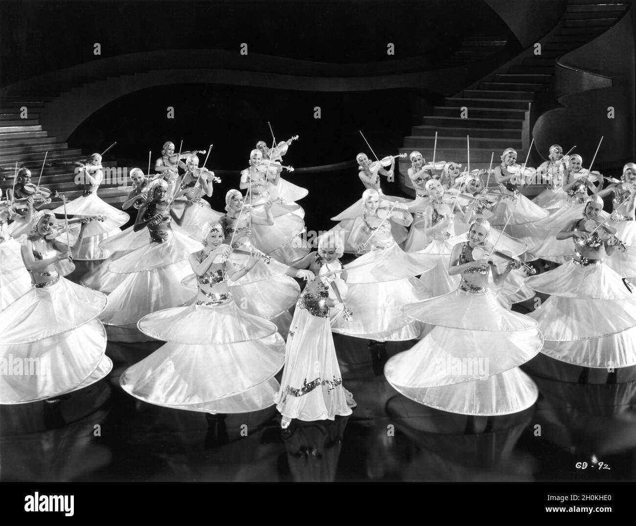 RUBY KEELER and Chorus Girls with Violins performing the Shadow Waltz number in GOLD DIGGERS OF 1933 director MERVYN LeROY musical numbers created and directed by BUSBY BERKELEY based on a play by Avery Hopwood costume design Orry-Kelly art direction Anton Grot Warner Bros. Stock Photo