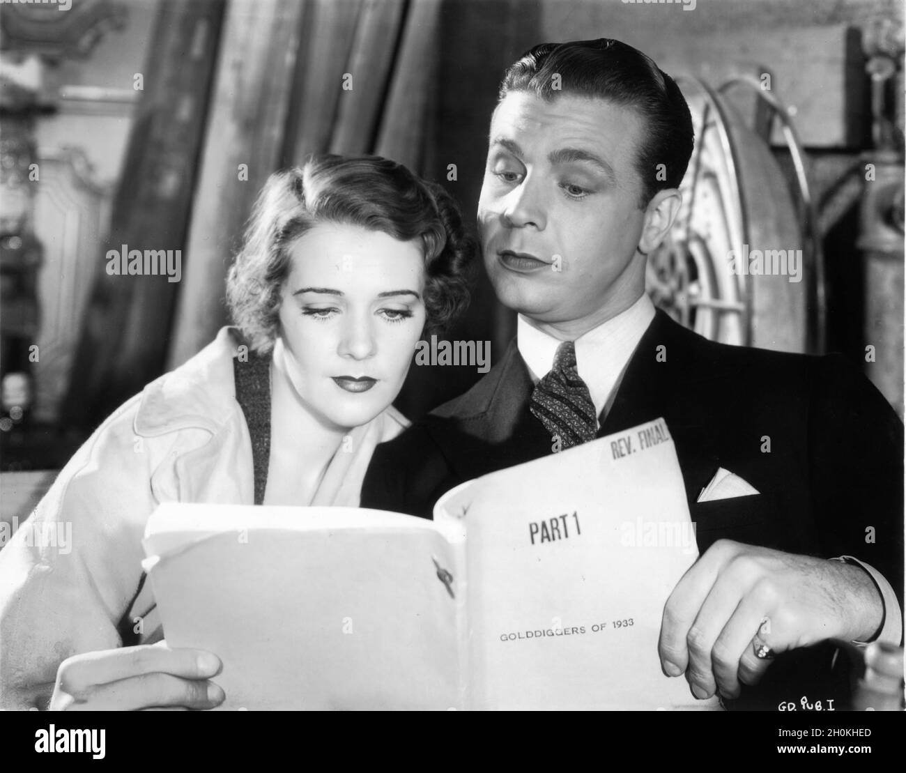 RUBY KEELER and DICK POWELL on set candid reading script during filming of GOLD DIGGERS OF 1933