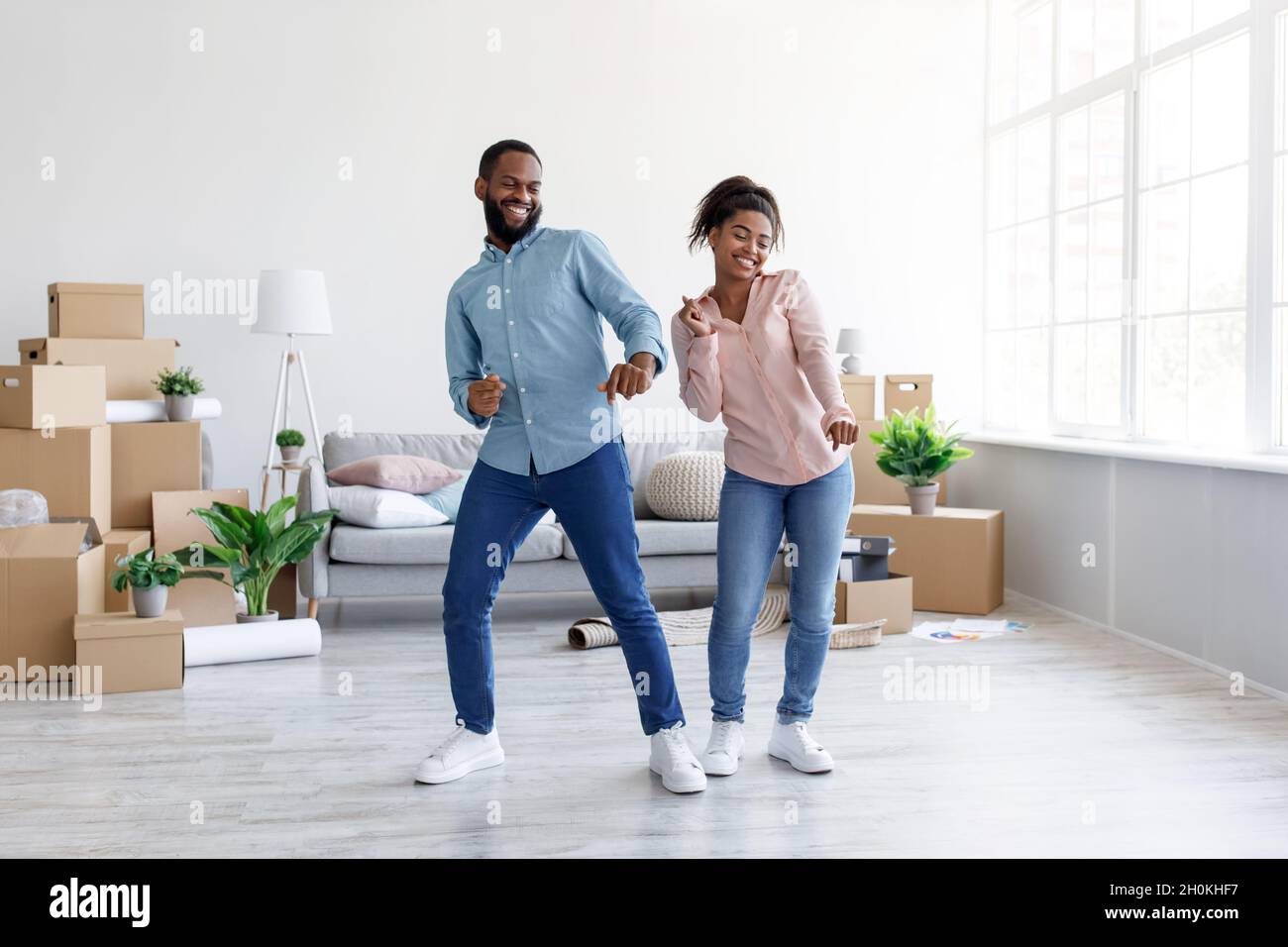 Smiling millennial african american husband and wife dancing together ...