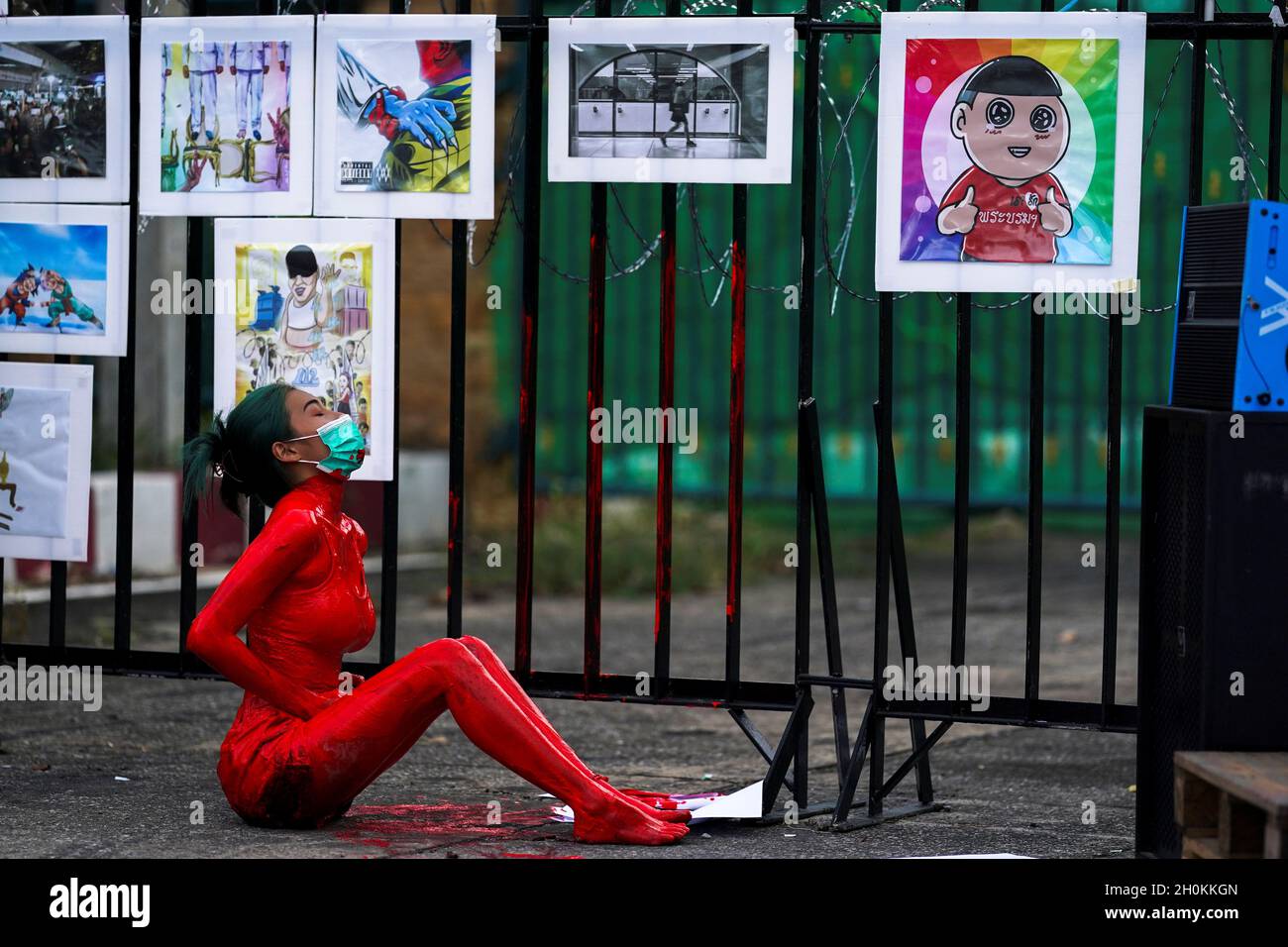 An anti-government protester covered in red paint performs during a protest against the Thai government demanding Prime Minister Prayuth Chan-ocha's resignation and the abolition of 112 Lese-Majeste law, in front of the Bangkok Remand Prison in Bangkok, Thailand, October 13, 2021. REUTERS/Athit Perawongmetha Stock Photo
