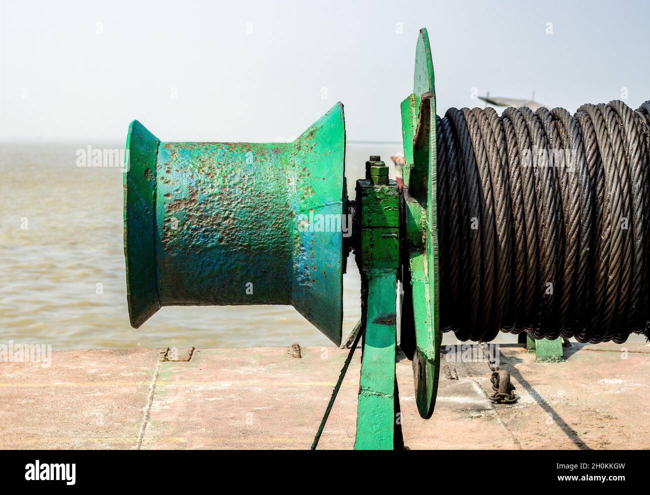 Old rusty iron anchor cable or ship rope spool close up view on the