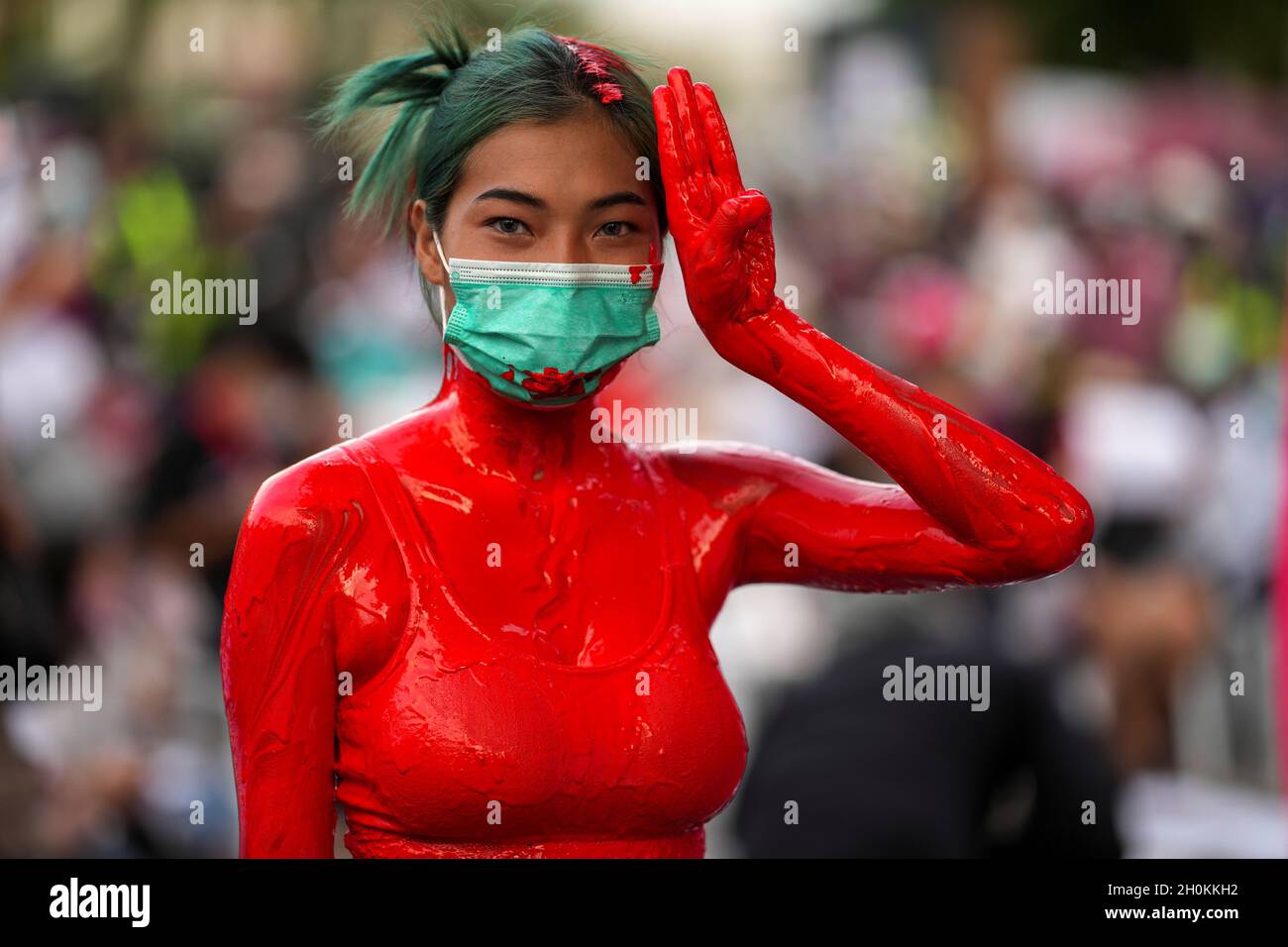 An anti-government protester covered in red paint flashes the three-finger salute during a protest against the Thai government demanding Prime Minister Prayuth Chan-ocha's resignation and the abolition of 112 Lese-Majeste law, in front of the Bangkok Remand Prison in Bangkok, Thailand, October 13, 2021. REUTERS/Athit Perawongmetha Stock Photo