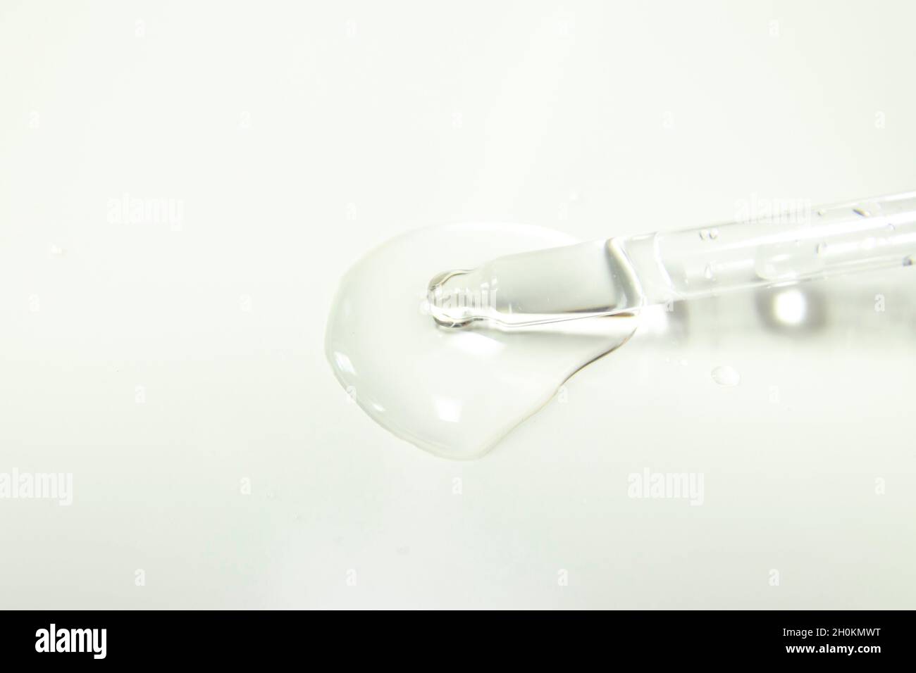 Drops from a pipette. Liquid gel or serum on a microscope screen on a white background Stock Photo