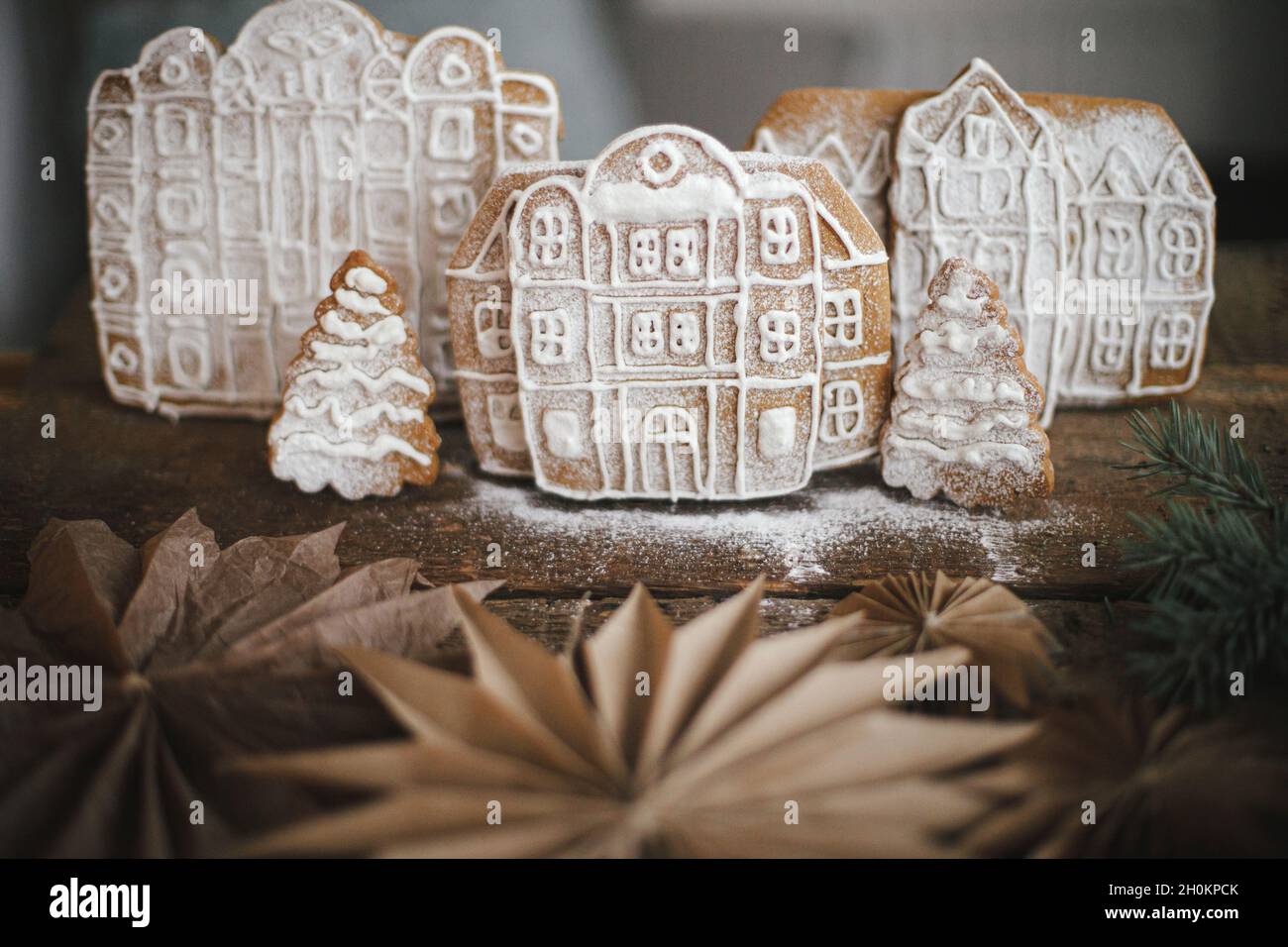 https://c8.alamy.com/comp/2H0KPCK/christmas-gingerbread-houses-and-tree-on-wooden-table-with-stars-in-rustic-scandinavian-kitchen-atmospheric-moody-image-christmas-holiday-preparatio-2H0KPCK.jpg