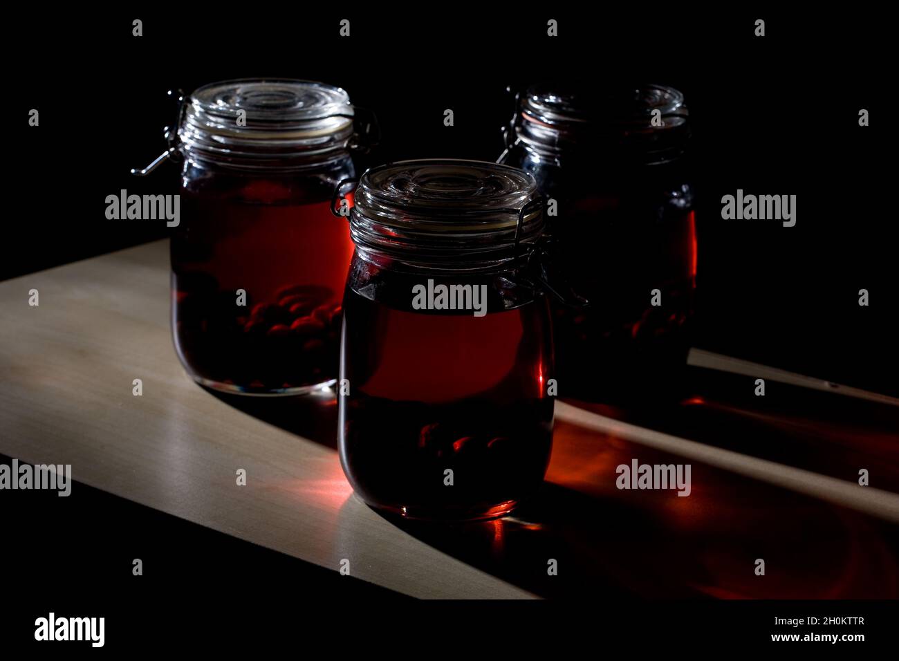 Home made sloe gin maturing and fermenting in kilner jars Stock Photo