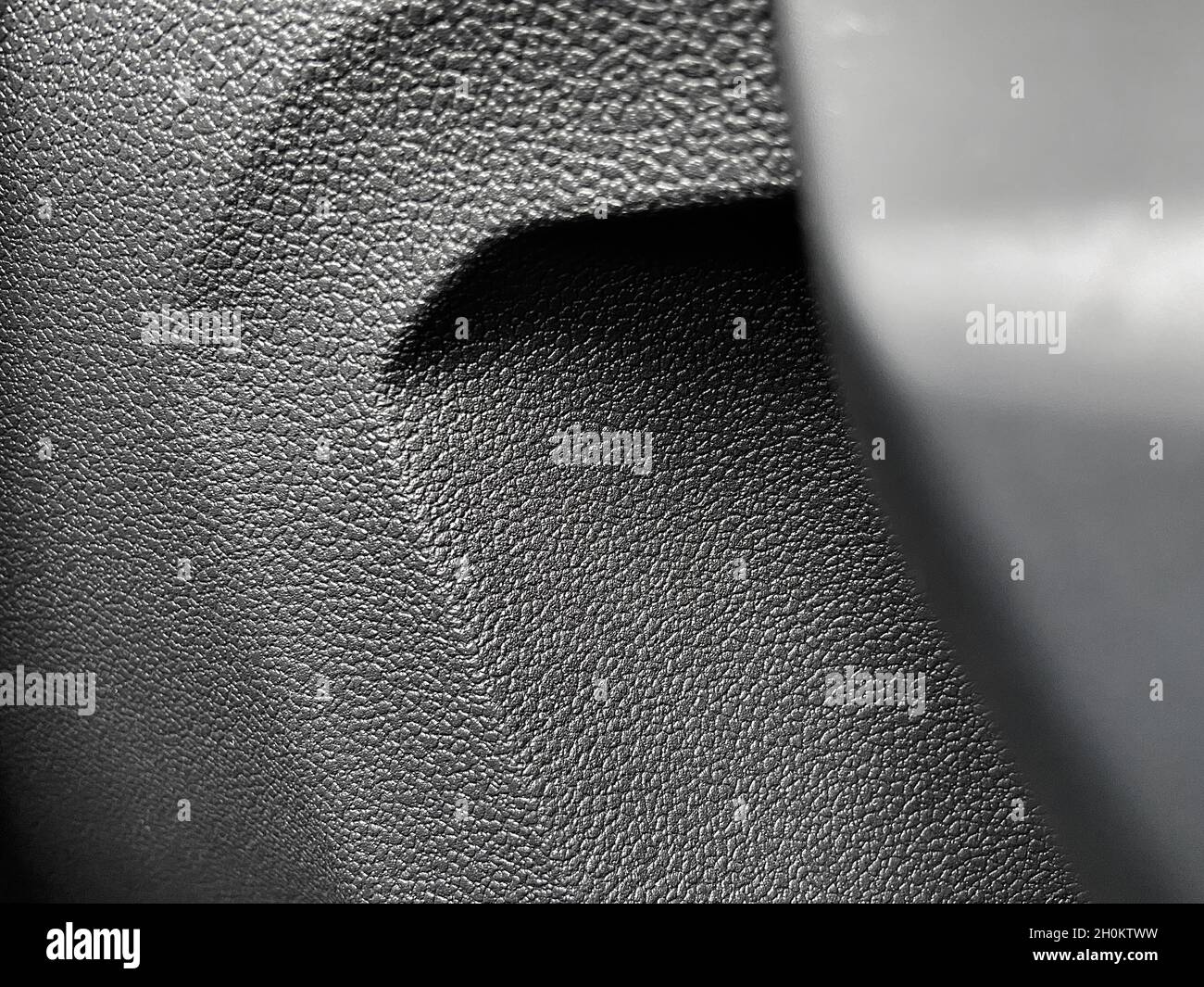 Closeup of the bumpy patterned gray plastic surface of a car's door ...