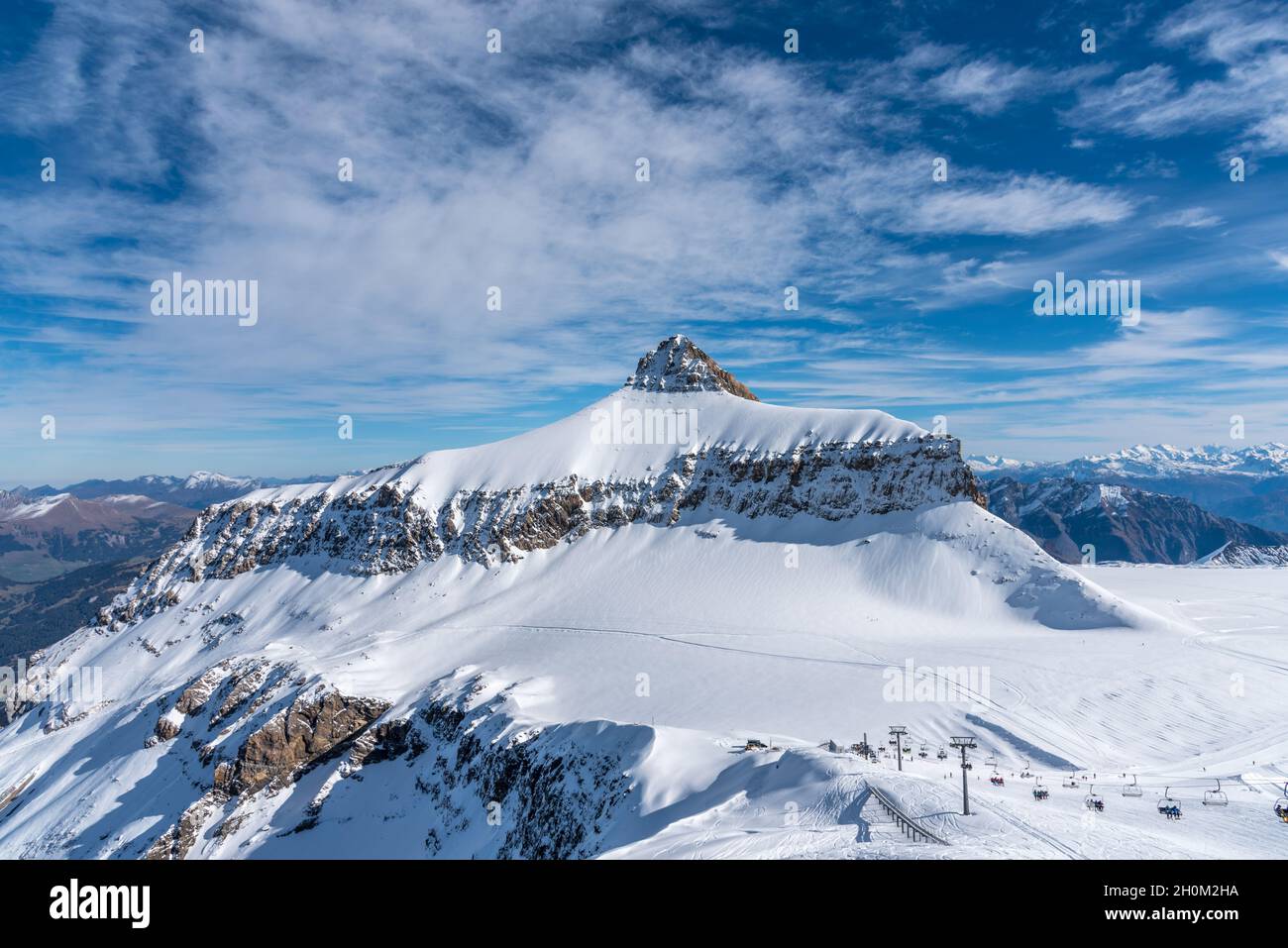 A winter day on the Diablerets glacier at 3000 meters above sea level in Switzerland with a blue sky with clouds. Stock Photo