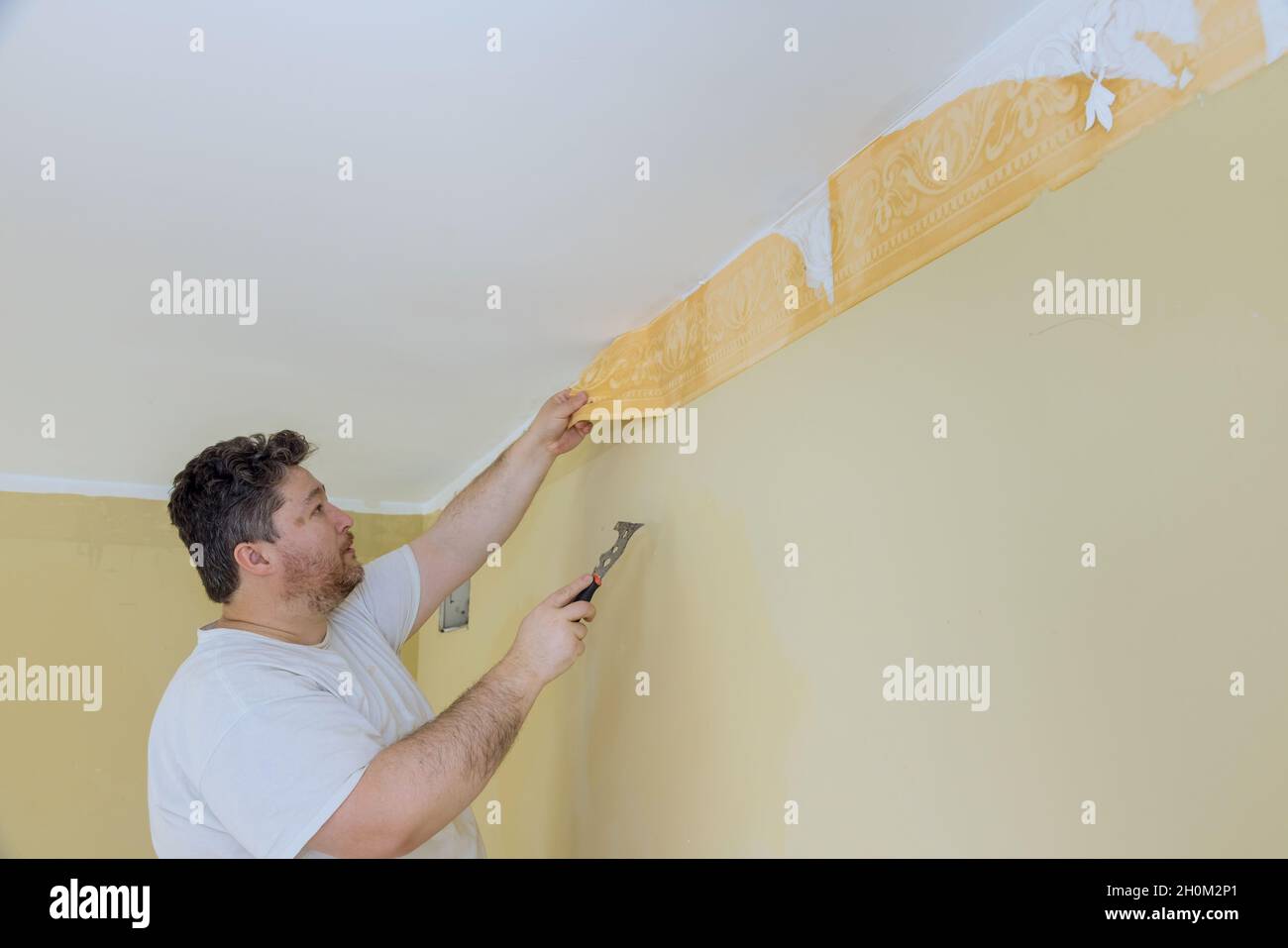 Manual work with scraper preparation for painting a room worker hand
