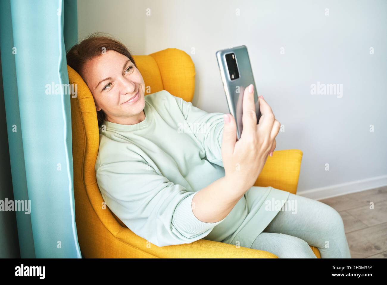 Young woman doing self portrait indoors. Home vacation portrait. Blogger selfie Stock Photo