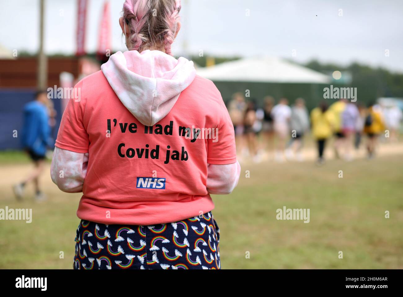 A worker at the Covid 19 Vaccination Centre tent waits and watches the crowds of young people at the Leeds Festival in west Yorkshire. Young people ar Stock Photo