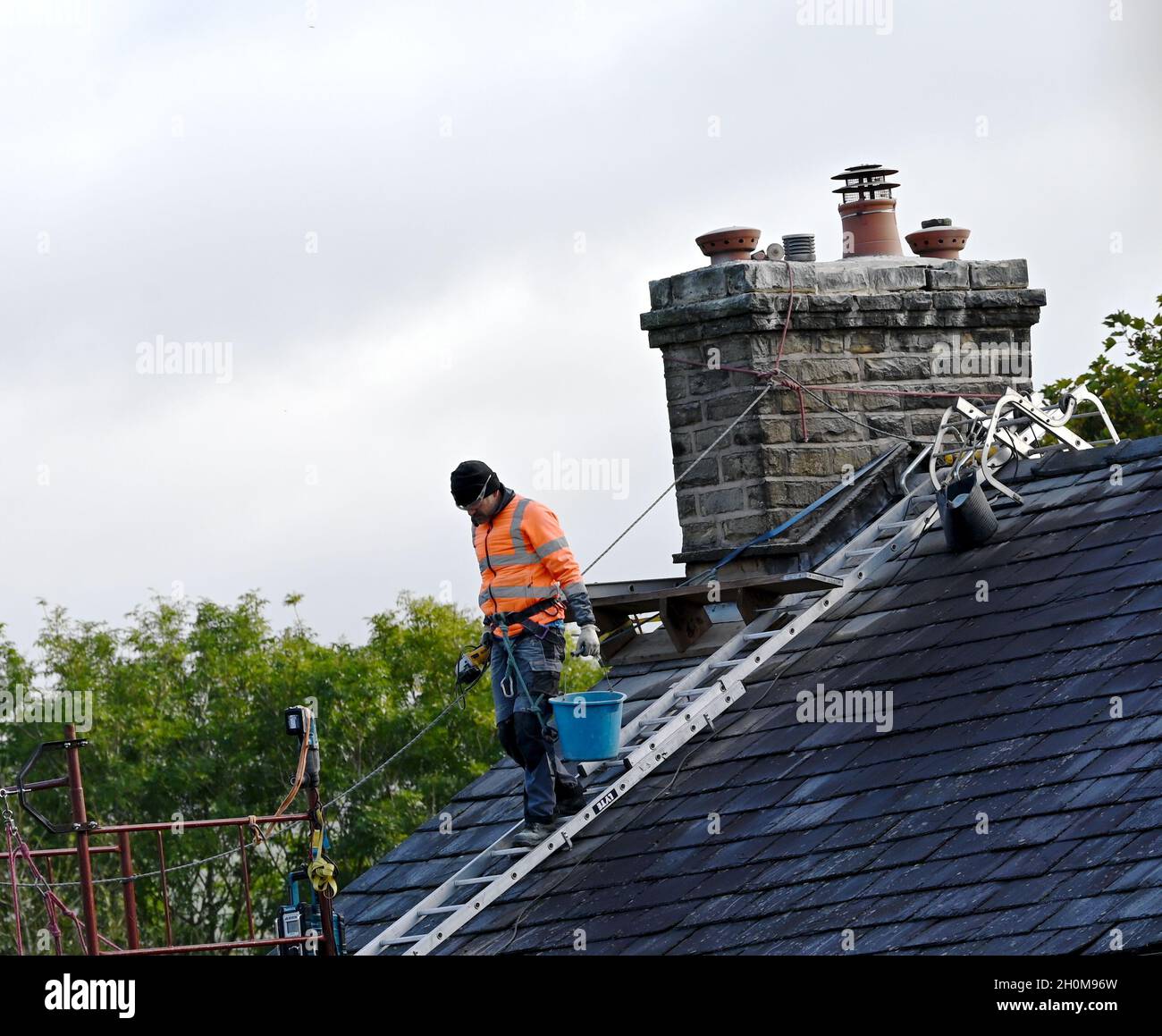 A workman working on a house roof Stock Photo