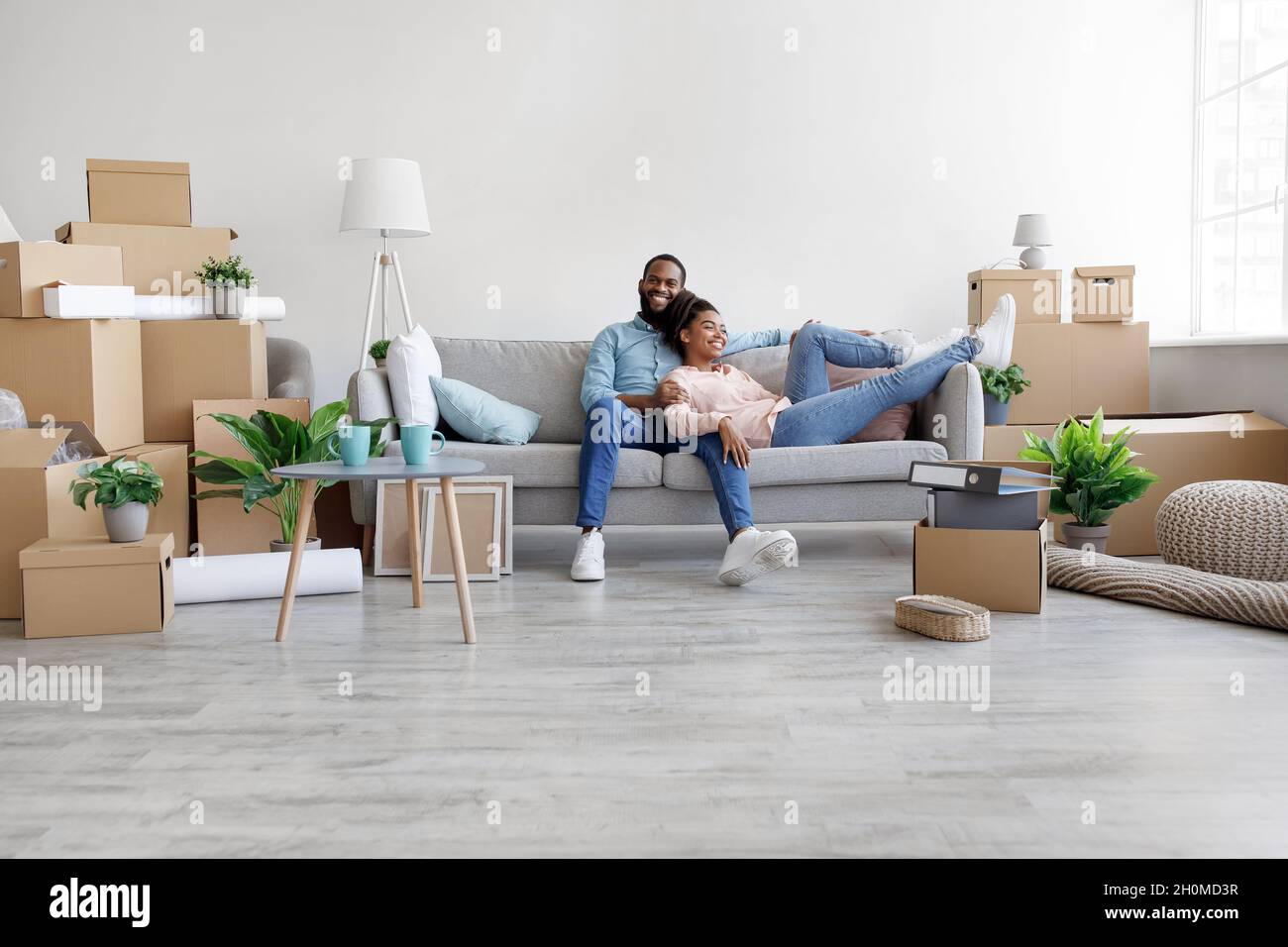 Happy glad young african american husband and wife relaxing on couch in ...