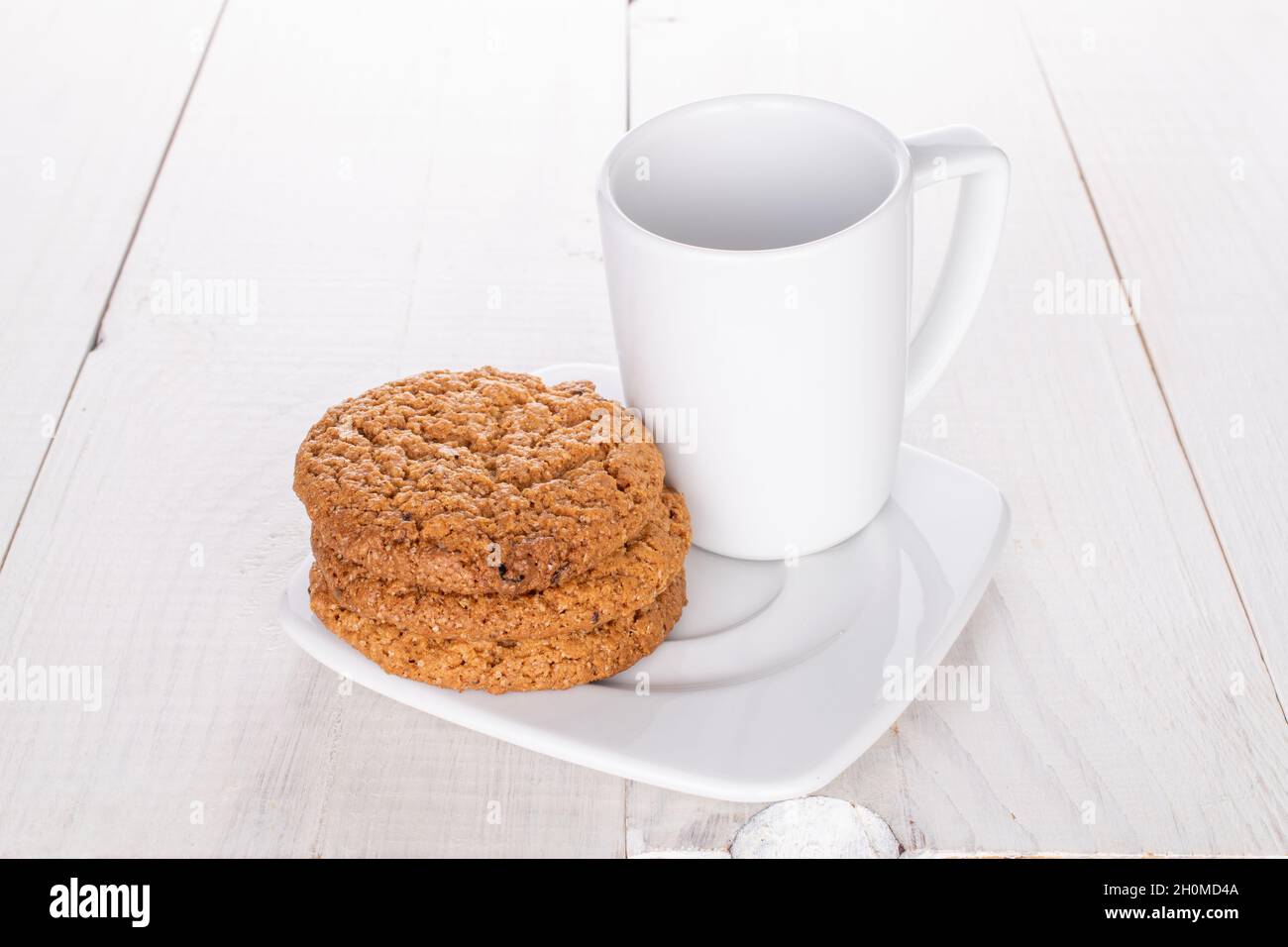 Several sweet oatmeal cookies with ceramic dishes, close-up, on a wooden table. Stock Photo