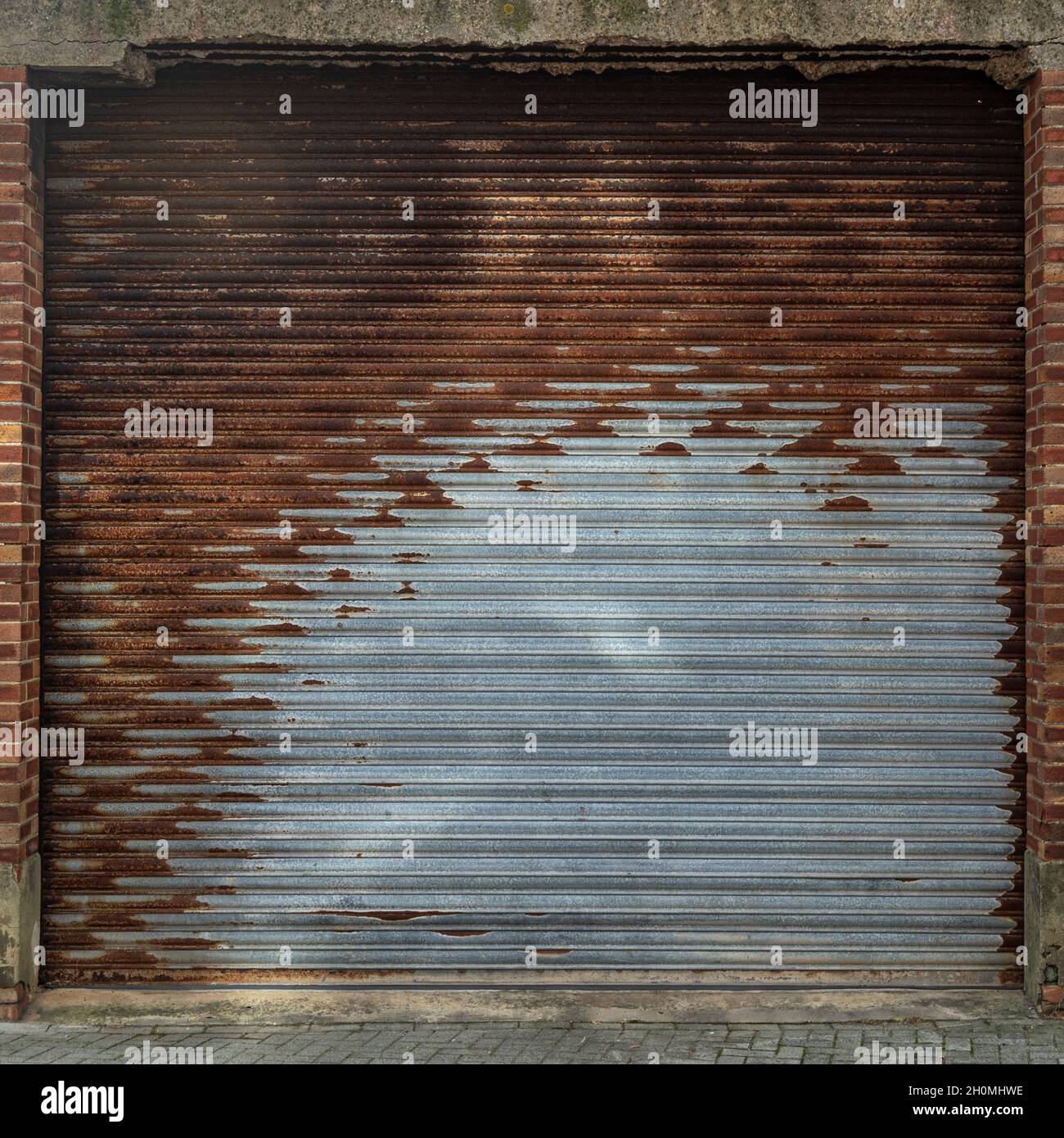 Weathered stainless steel roll up door. Rusty iron gate. Metal roller door. Metallic roller shutter door Stock Photo