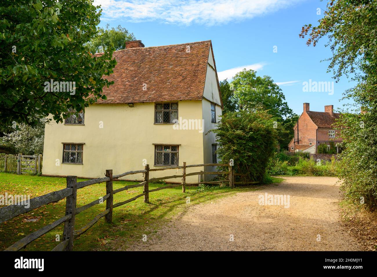 The historic cottage Willy Lott's House seen from the road near Flatford Mill (seen to the right) in Flatford, Suffolk, England. Stock Photo