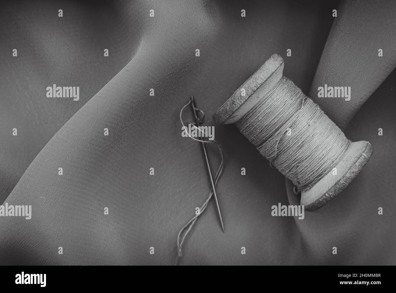 Vintage retro spool of thread on a black and white fabric background