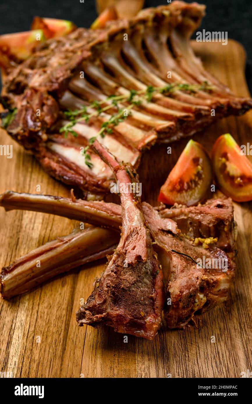 Closeup view of grilled rack of lamb on a plate with spicy sauce Stock Photo