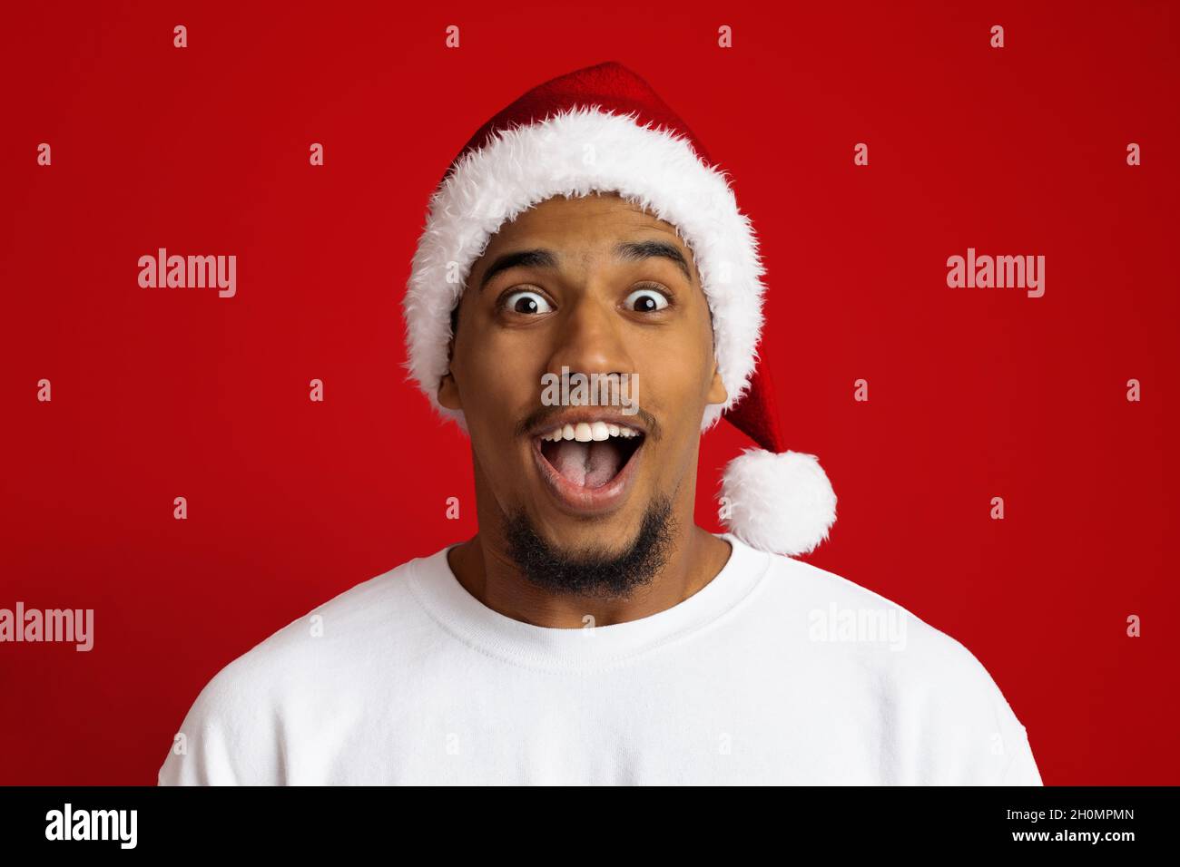 Closeup of surprised black guy in santa hat Stock Photo Alamy
