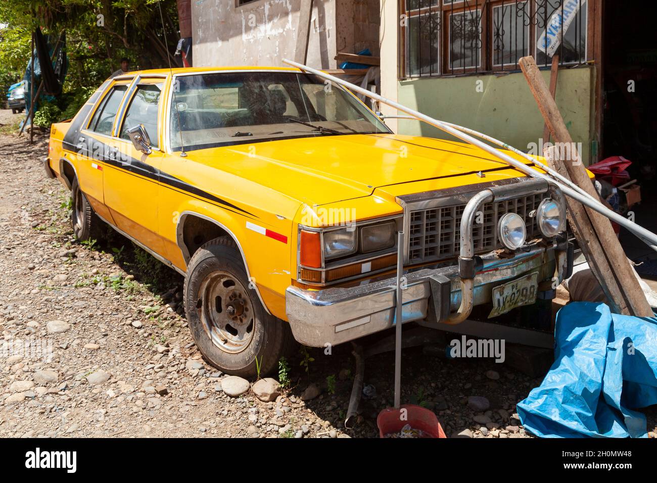 Pilcopata, Peru - April 10, 2014: An old and big yellow car, rests parked in the surroundings of the small town of Pilcopata Stock Photo