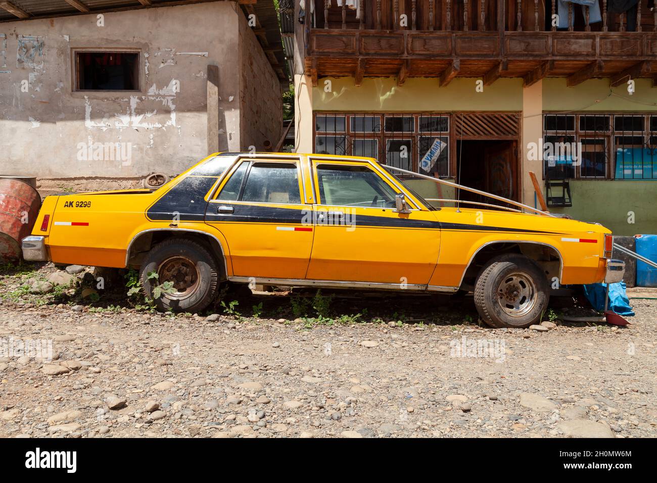 Pilcopata, Peru - April 10, 2014: An old and big yellow car, rests parked in the surroundings of the small town of Pilcopata Stock Photo