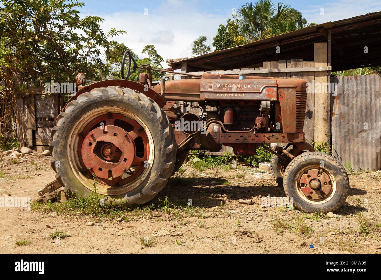 Pilcopata, Peru - April 12, 2014: An old tractor, Mc Cormick International Farmall, totally rusted and abandoned, in one of the streets of Pilcopata Stock Photo