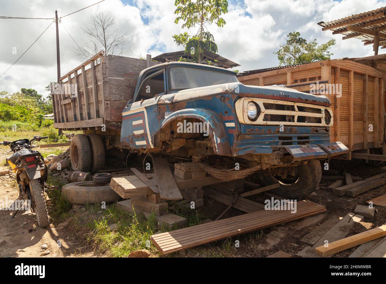 Pilcopata, Peru - April 12, 2014: An old rusty and abandoned truck, half scrapped, rests in one of the streets of Pilcopata Stock Photo