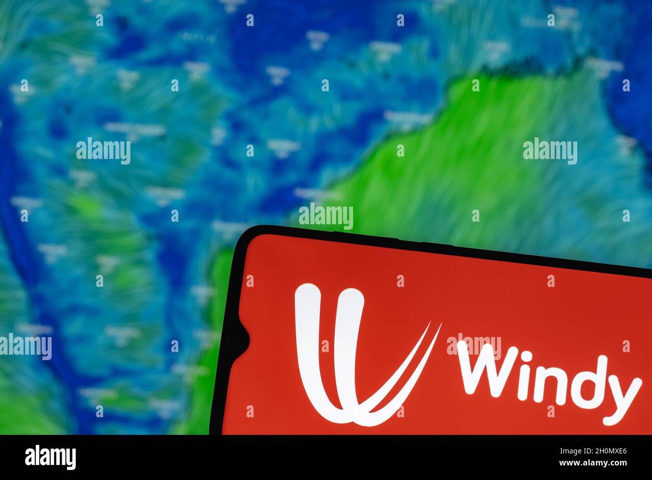 Windy is interactive weather forecasting service worldwide. Windy logo on smartphone screen. On the background of the weather forecast over India. Stock Photo