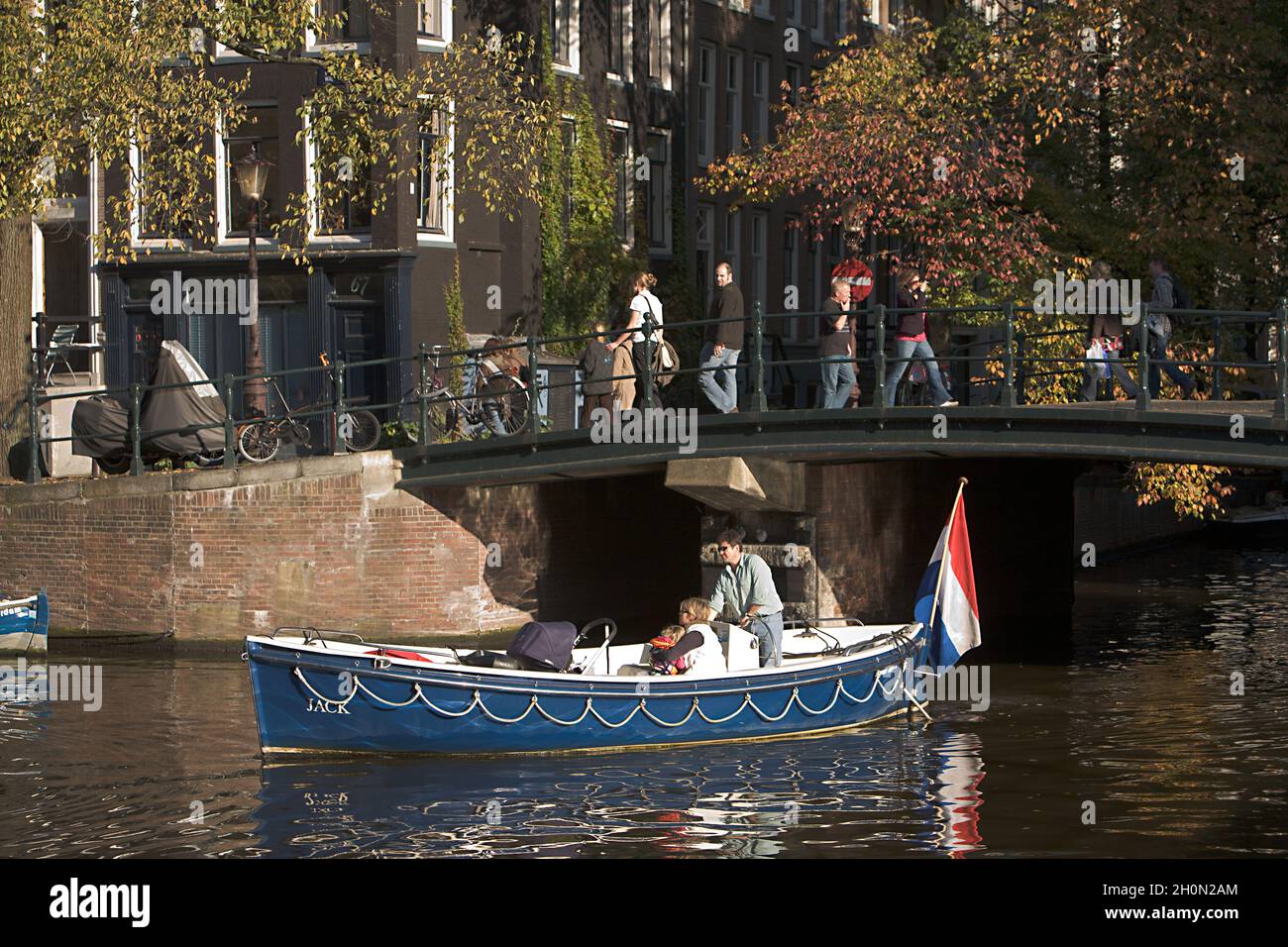 NETHERLANDS, NORTH HOLLAND, AMSTERDAM. FAMILY LINGERING ON KLOVENIERS BURG WAL CANAL, OUDE ZIJDE Stock Photo