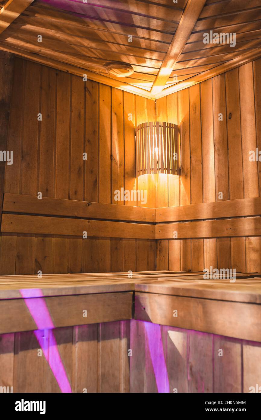 Cozy wooden steam room in the sauna with warm lighting and light wood