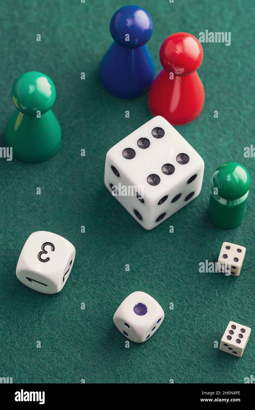 Colored board game figures with dice. Board games concept Stock Photo