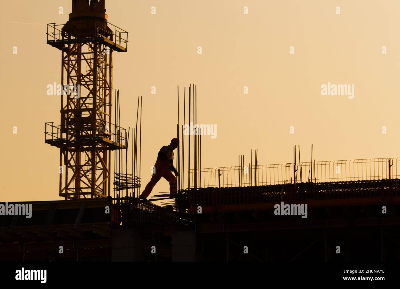 Construction worker jumping over hole in structure. Safety at work concept Stock Photo