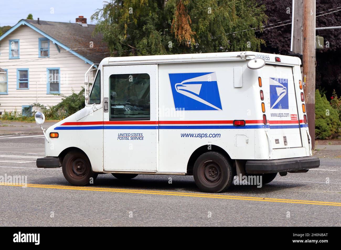 A Grumman Long Live Vehicle being used as a US Mail delivery truck on a street. Stock Photo