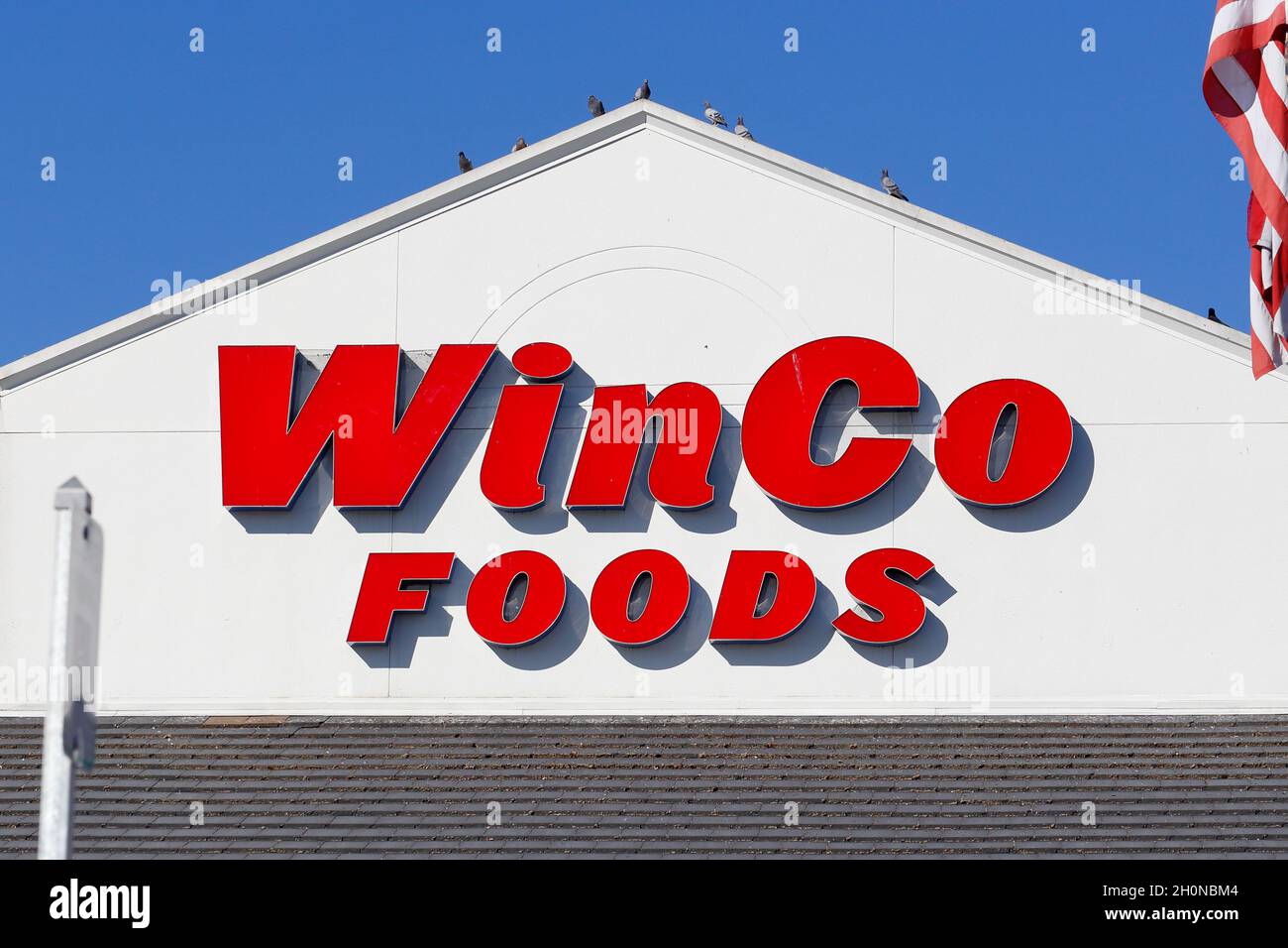 A WinCo Foods supermarket sign on a wall against a sunny sky Stock Photo